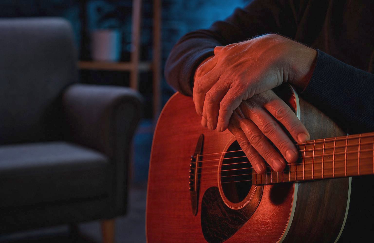 Hände ruhen sanft auf den Saiten einer Akustikgitarre in einem Therapieraum